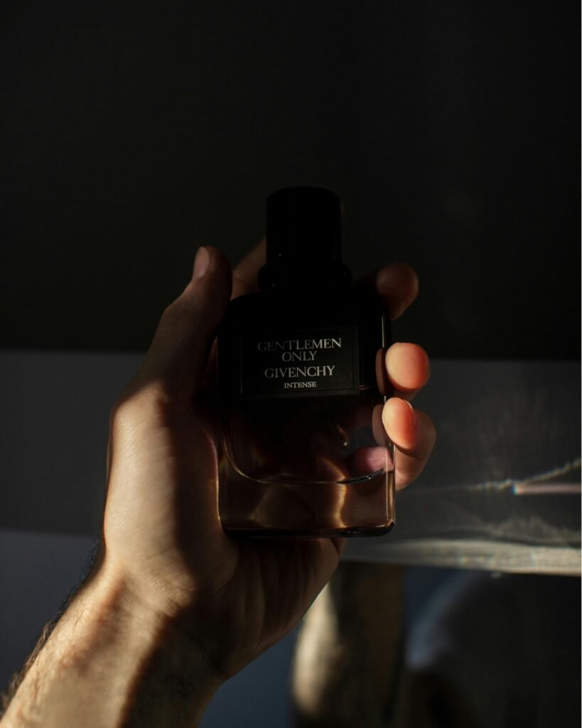 homem segurando frasco de perfume no site perfume e poesia