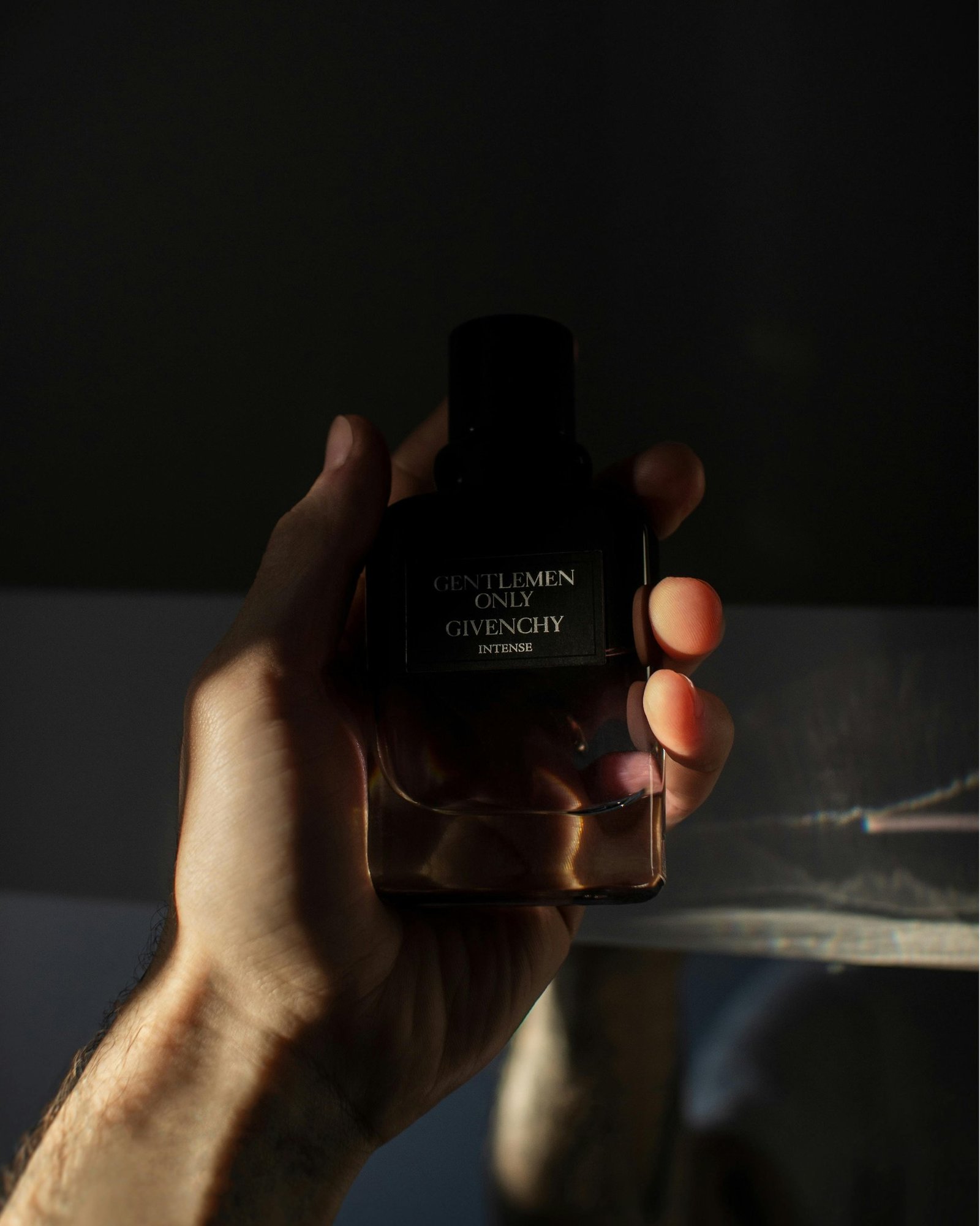 homem segurando frasco de perfume no site perfume e poesia